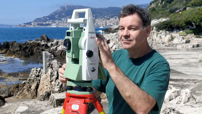 Géomètre-expert réalisant un relevé topographique en environnement littoral des Alpes-Maritimes