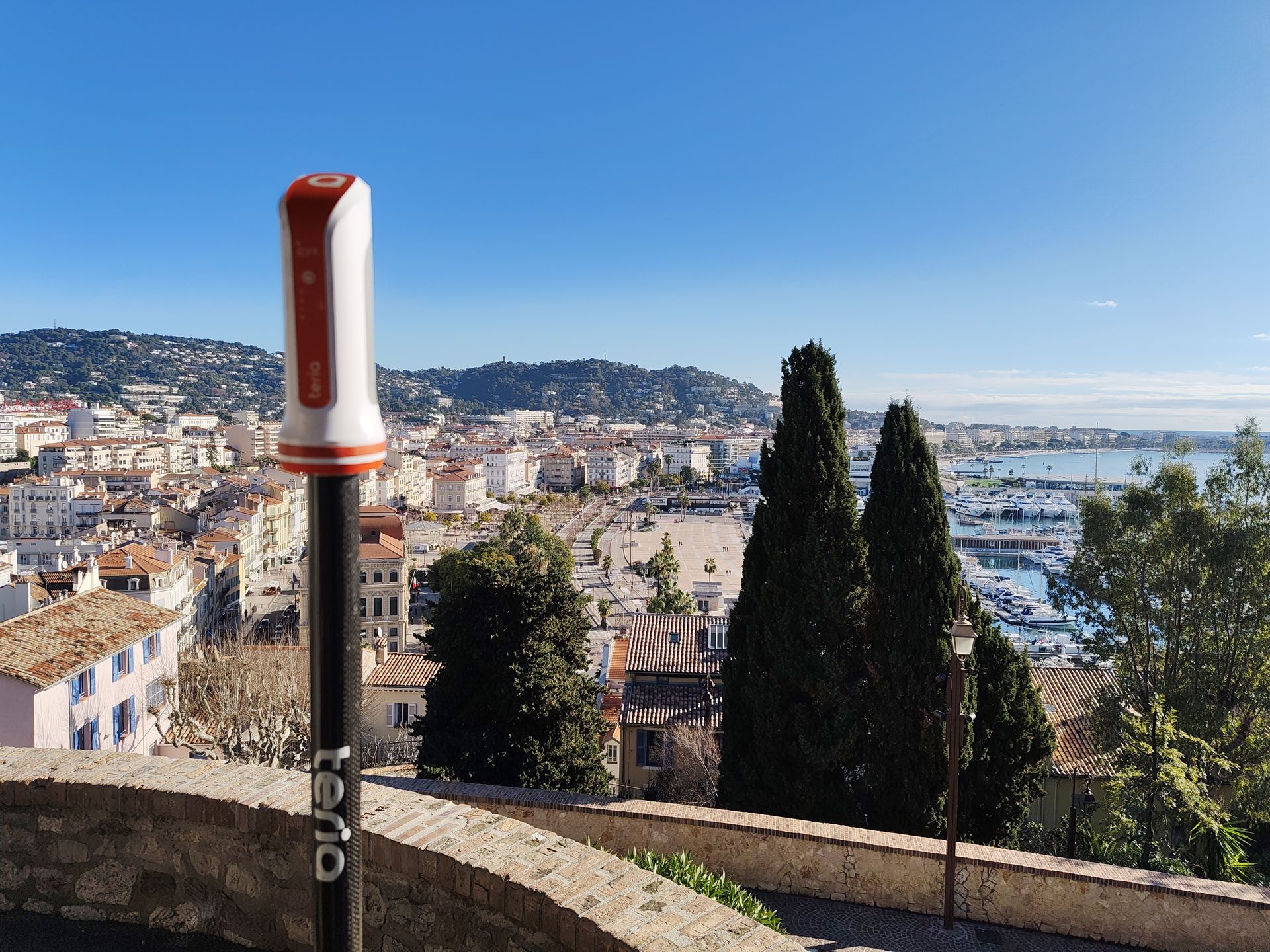 Récepteur GNSS de géomètre-expert surplombant une zone urbaine littorale des Alpes-Maritimes